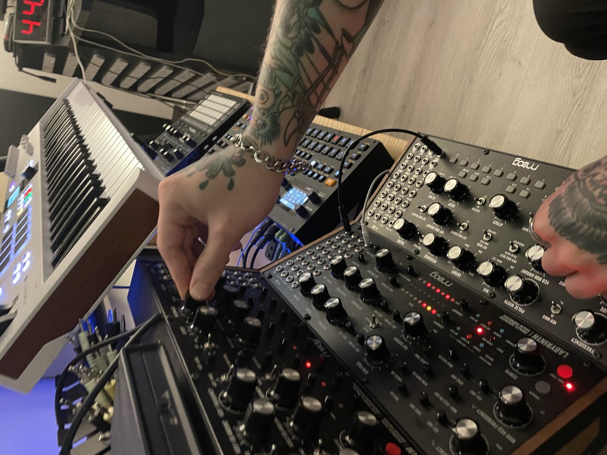 Detalle de manos ajustando un sintetizador Moog en el estudio